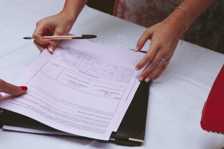 Deux mains écrivant sur un document posé sur un bureau