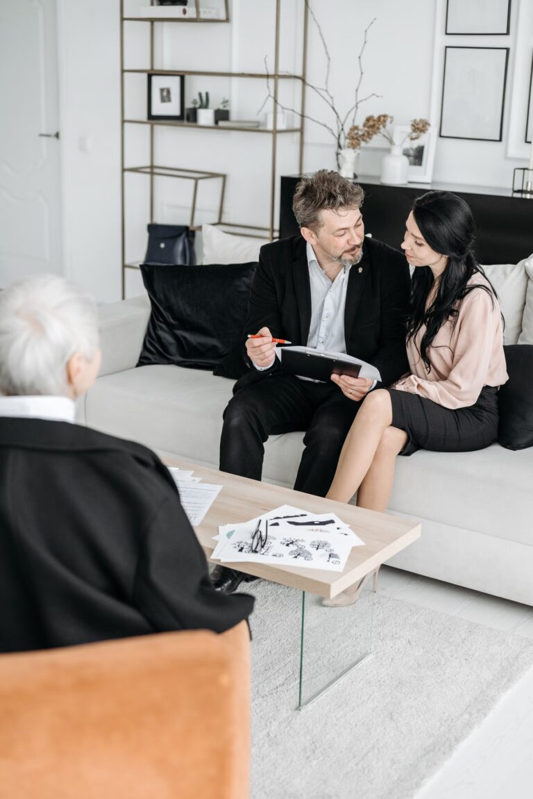 Un couple examine des documents avec un conseiller assis en face de lui