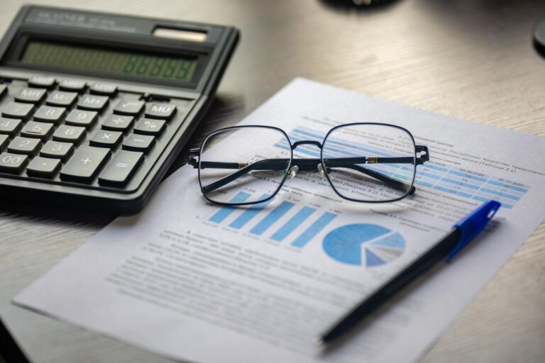Avis d'imposition posé sur un bureau avec une calculatrice et une paire de lunettes