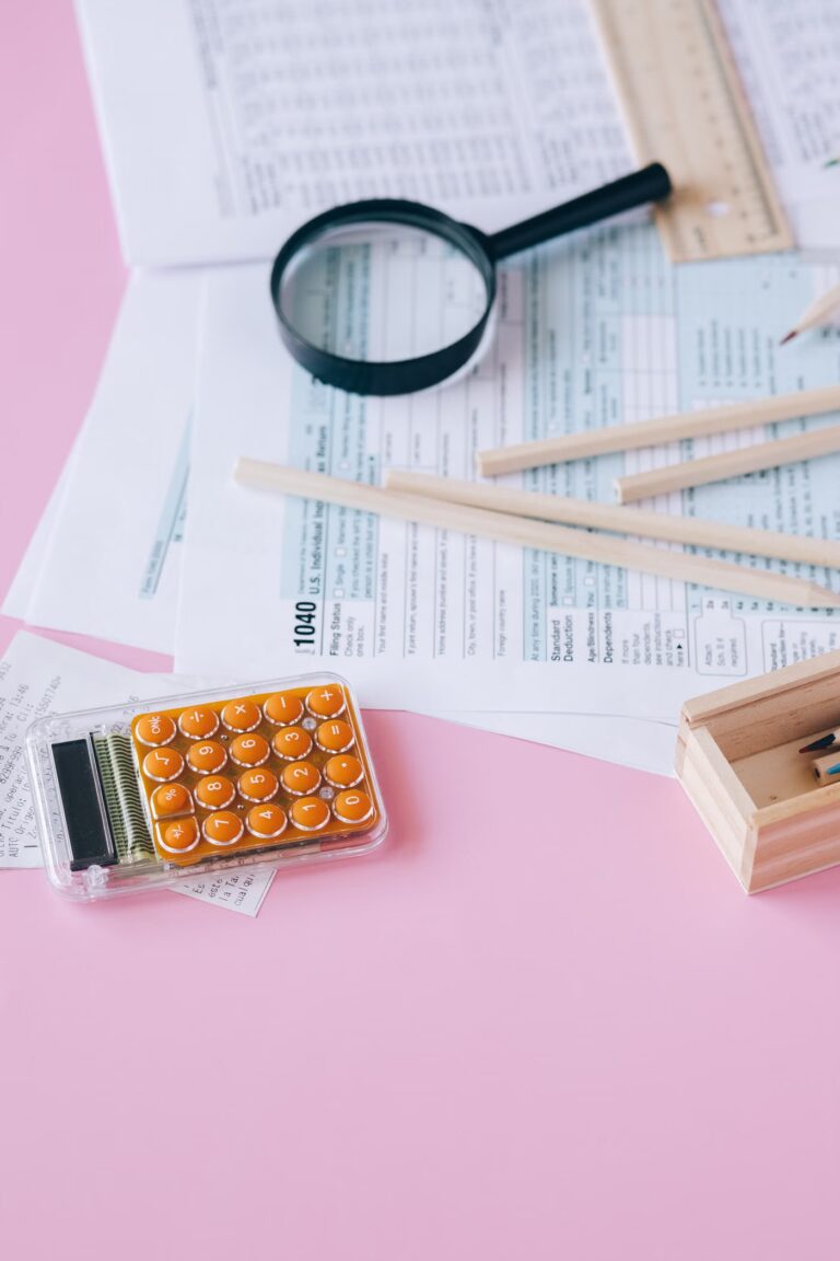 Calculatrice, documents fiscaux et stylo posés sur un bureau clair