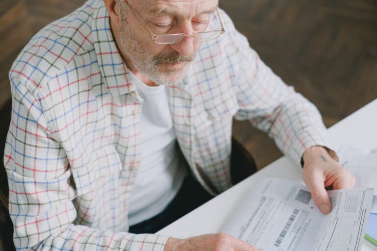 Homme âgé portant des lunettes qui consulte des documents